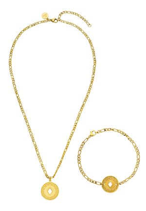 Goldene Kettenhalskette und passendes Armband, jeweils mit einem runden dekorativen Anhänger mit einem diamantförmigen Ausschnitt in der Mitte.