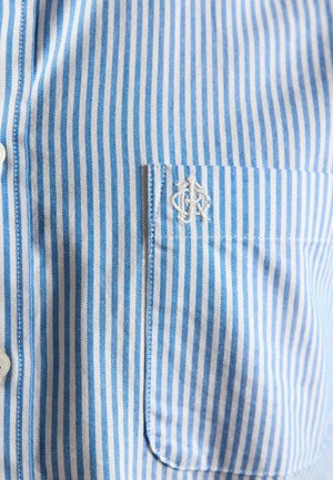 Siniste ja valgete vertikaalsete triipudega särk, millel on rinnal tasku ning tasku kohal valgete tikitud initsiaalidega.