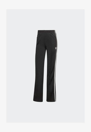 Pantalons de survêtement Adidas noirs avec des bandes blanches sur les côtés, taille élastique, poches zippées et logo Adidas sur la cuisse supérieure.