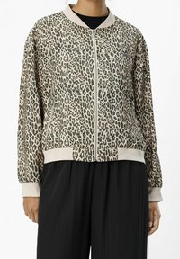 Blouson aviateur zippé à imprimé léopard en tons beige et vert, avec col et poignets côtelés, offrant une coupe décontractée et une texture douce.