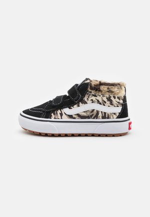 Zapatilla alta con ante negro, tela de estampado de leopardo, franja lateral blanca, dos correas negras de velcro y forro de piel marrón claro alrededor del tobillo.