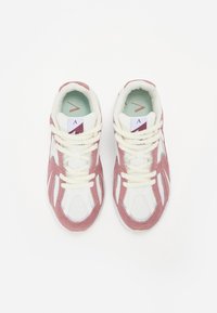 White and light pink athletic sneakers with mesh fabric, suede accents, and cream-colored laces. Features a mint green inner lining.