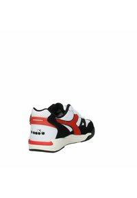 Scarpa atletica nera, bianca e rossa con tomaia in rete e camoscio, dotata di una suola imbottita e un logo prominente sul tallone.