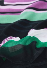 Tessuto a righe in viola, verde, bianco e nero; texture liscia, materiale leggero, con una leggera lucentezza e un drappeggio morbido.