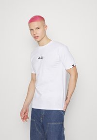 Weißes T-Shirt mit kurzen Ärmeln und schwarzem "ellesse"-Logo auf der Brust; verfügt über einen klassischen Rundhalsausschnitt und besteht aus weichem Baumwollmaterial.