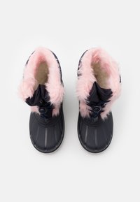 Námořnické voděodolné boty s načechranou růžovou podšívkou, texturovaným černým gumovým vnějším pláštěm a nastavitelným stahováním pro lepší přizpůsobení. Zakulacená špička a protiskluzová podrážka.