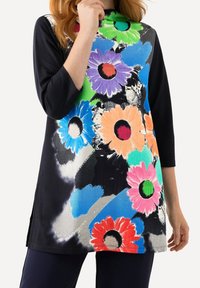 Schwarze Blumentunika mit lebhaften, großen, mehrfarbigen Blumen (rosa, orange, blau, grün) und abstrakten blauen Mustern, mit 3/4-Ärmeln.