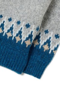 Maglione grigio lavorato a maglia con motivi a stella blu, bianchi e beige lungo l'orlo, caratterizzato da una finitura testurizzata e polsini a coste.