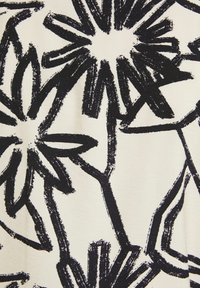 Černý květinový vzor na krémovém materiálu, s výraznými obrysy ve stylu štětce. Design obsahuje různé tvary květin a stonků.