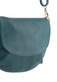 Tyrkisblå lædertaske med skulderrem, klaplukning, lås i guldfarve og præget "VENEZIA"-logo på forsiden.