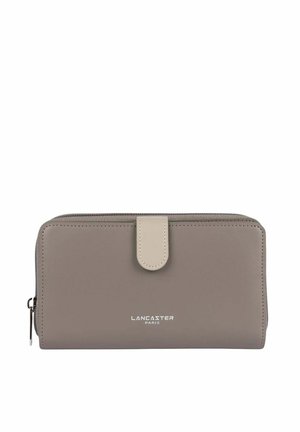 Portefeuille en cuir gris avec une fermeture à bouton crème, un dessus zippé et le logo en relief "LANCASTER PARIS" à l'avant. Texture lisse et forme rectangulaire.