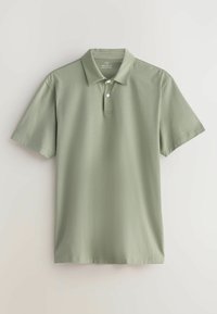 Polo vert clair à manches courtes avec deux boutons blancs et un col classique, présenté à plat sur un fond clair.