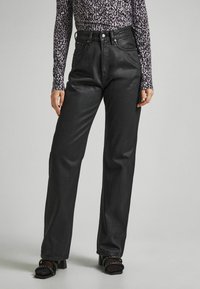 Vaqueros de mezclilla negros con cintura alta, diseño de pierna recta y dos bolsillos frontales. Presentan herrajes en tono plateado y un brillo sutil.
