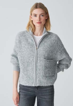 Light gray zip-up sweater with a soft, fluffy texture, ribbed cuffs, and a front pocket. Features a high collar and relaxed fit.