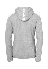 Grijze sweatshirt met capuchon, voorzien van witte accenten op de schouders en een groot "Kempa" logo op de achterkant. Zachte textuur, lange mouwen.