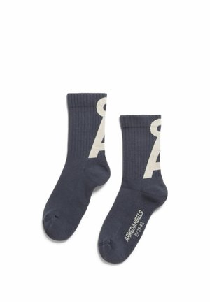 Dunkelgraue gerippte Socken mit großem weißem Buchstaben "A" an den Seiten und "ARMANDANGELS EU 43-42" auf der Sohle eines Sockens gedruckt.