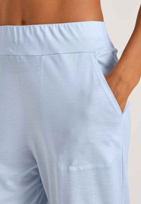 Lichtblauwe sportbroek met een elastische tailleband, zijzakken en platte naden voor comfort en bewegingsgemak.