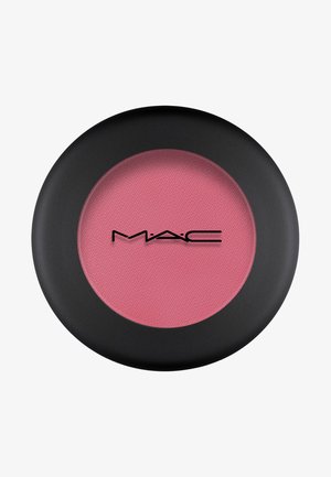 Compact per blush MAC rotondo con una custodia nera opaca, che presenta un interno in polvere rosa chiaro e morbido con superficie texturizzata e logo.