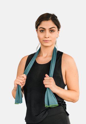 Fitness-Handtuch mit einer strukturierten, atmungsaktiven Gestaltung in Türkis mit grünen Akzenten, um die Schultern gelegt vor einem neutralen Hintergrund.