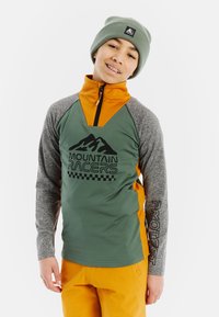 Zelený a oranžový pletený sveter s šedými rukávmi, dizajn s polovičným zipsom, čierna grafika "Mountain Racers" a čiapka s detailom loga.