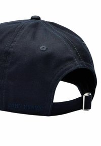 Mörkblå bomullscap med en böjd skärm, stickade detaljer och ett justerbart band med en silverfärgad metallspänne. "JOHN HENRIC" broderat på baksidan.