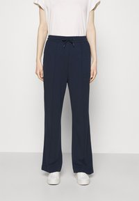 Navy wide-leg pants made of soft fabric with a drawstring waistband, featuring clean lines and two vertical seams along the front.