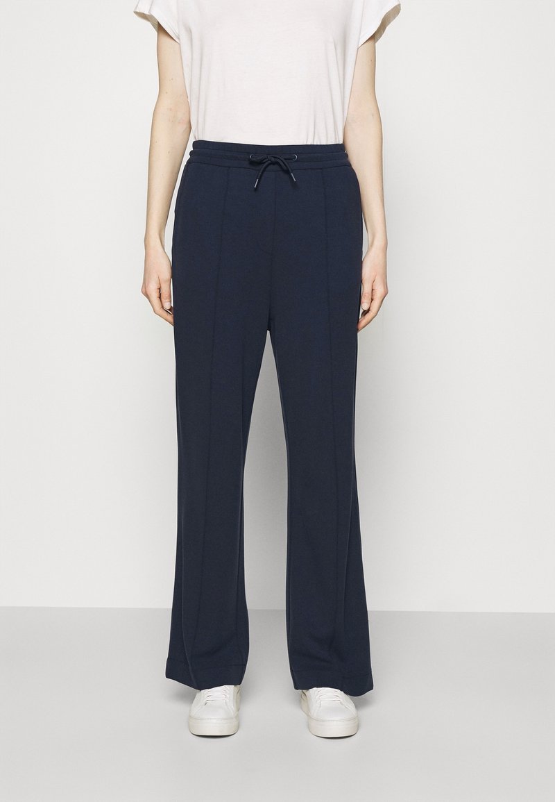 Navy wide-leg pants made of soft fabric with a drawstring waistband, featuring clean lines and two vertical seams along the front.