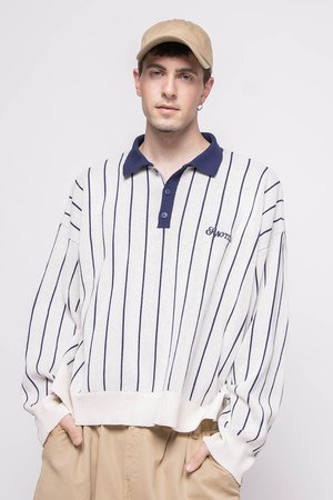 Polo blanco de manga larga con franjas navy, puños acanalados y color navy en el cuello. Un pequeño logo está bordado en el lado izquierdo. Ajuste casual.