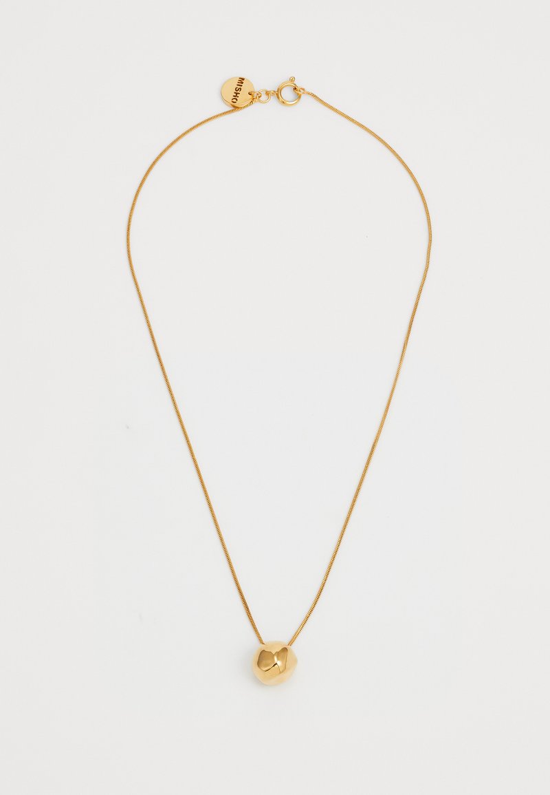 Colar em tom de ouro com uma corrente fina e um pendente geométrico apresentando uma forma arredondada e polida, além de um detalhe em forma de coração.
