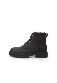Botines negros con parte superior de cuero liso, acentos de ante, diseño con cordones y suela de goma texturizada. Presenta un collar acolchado.