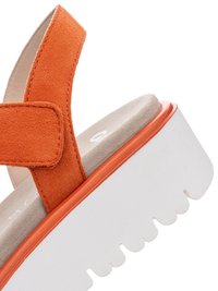 Open-toe sandal with orange suede straps, beige cushioned footbed, and thick white ridged platform sole.