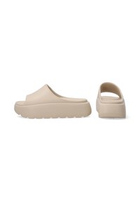 Beige gummisandaletter med åben bag, rund tå og struktureret sål. Har en tyk platform for ekstra højde og komfort.