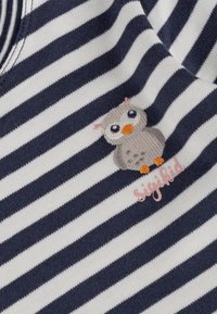 Stoff mit navy- und weißen Streifen zeigt ein gesticktes Eulendesign mit grauen, orangen und blauen Akzenten, neben dem Markennamen "Sigikid".