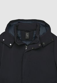 Dunkelblau, gefütterte Jacke mit hohem Kragen, Druckknöpfen und Reißverschluss. Weiche Innenauskleidung und strapazierfähiger Außenstoff.
