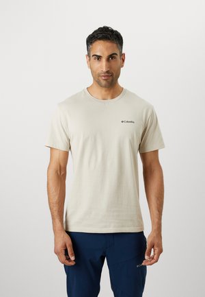 Beige cotton t-shirt with a crew neck and short sleeves. Features a small black logo on the left chest. Smooth texture, relaxed fit.