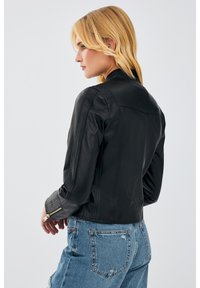 Black leather jacket with a fitted design, zippered cuffs, and seams detailing. The back features a simple collar and smooth texture.