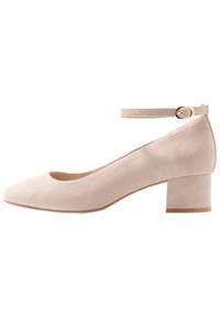 Décolleté in suede beige con punta arrotondata e cinturino alla caviglia. Presenta un tacco medio-blocco per garantire stabilità. Texture liscia con un design semplice.