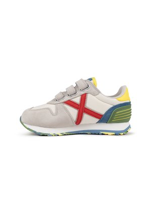 Zapatilla con parte superior de gamuza y textil gris, acentos laterales rojos, suela multicolor y cierre con correa. Presenta un cuello y lengüeta acolchados.