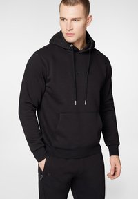Czarna kurtka z kapturem, z troczkami, przednią kieszenią i haftowanym logo. Oferuje gładką teksturę oraz dopasowany krój, w komplecie z pasującymi dresami.