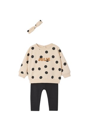 Beige long-sleeve polka dot sweatshirt with "JOLIE" text, black pants, and matching beige polka dot headband for a toddler.
