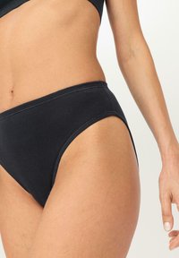 Zwarte katoenen bikini brief met een hoge beenopening en een zachte tailleband, met eenvoudige stiksels zonder extra patronen of accenten.