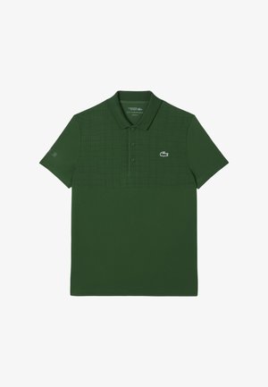 Grön pikétröja i texturerad tyg, med ett subtilt mönster på övre halvan, tre-knapps knäppning och broderad logotyp på bröstet.