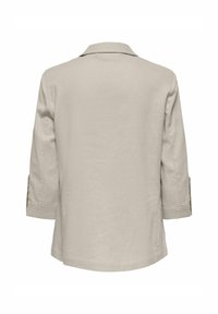 Blazer beige in lino con colletto, maniche a tre quarti e polsini arrotolati. Tessuto texturizzato con una finitura liscia e senza decorazioni visibili.