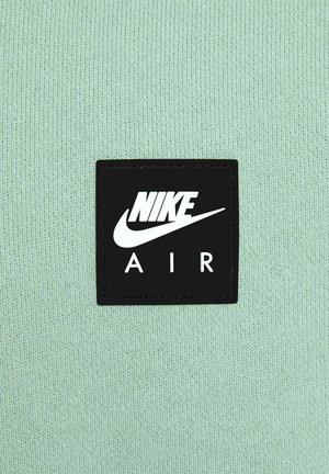 Mint green knitted fabric features a black square badge with white text "NIKE" above "AIR" and a white Nike swoosh logo.