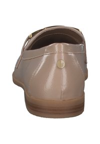 Zapatos de charol nude tipo slip-on con un tacón redondeado, que cuentan con un pequeño detalle dorado y una suela marrón texturizada.