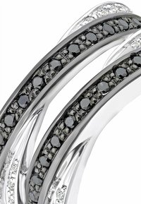 Srebrni višeband prsten saizmjenjivim redovima crnih kamenčića i prozirnih akcenata, s poliranim, elegantnim završetkom i složenim dizajnerskim detaljima.