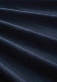 Tela azul marino con una textura suave, mostrando pliegues suaves y fluidos y un ligero brillo, que resalta su caida y suavidad.
