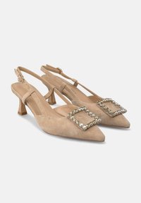 Tacchi slingback in suede beige con punta affusolata, piccoli tacchi a blocco e fibbie quadrate decorate con gemme trasparenti.