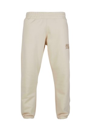 Cremfarbene Jogginghose aus weichem Stoff, mit elastischem Bund und gerippten Beinabschlüssen. Besitzt ein dezent gesticktes Logo an der Seite.