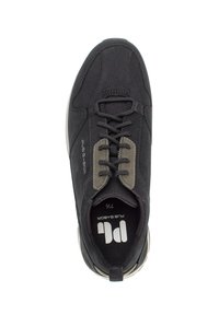 Zapatilla deportiva negra con parte superior de ante y textil, punta redonda, cordones y cuello acolchado. Presenta detalles en gris y un logotipo en la plantilla.